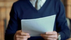 Confident businessman standing in a modern café, reviewing printed reports while working on the go. Focus on professional lifestyle, productivity, and remote work. - Powered by Shutterstock - Get 15% off with code: PIKWIZARD15