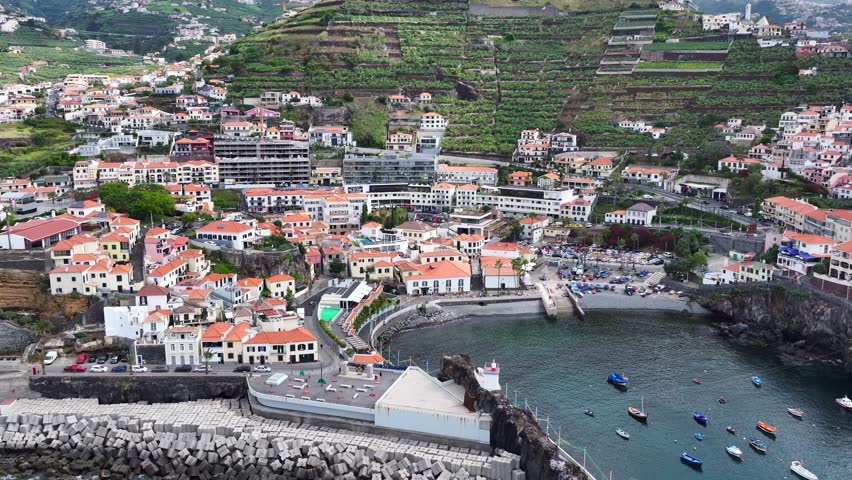 Quaint Câmara de Lobos fishing village on Madeira. Telephoto drone pullback view