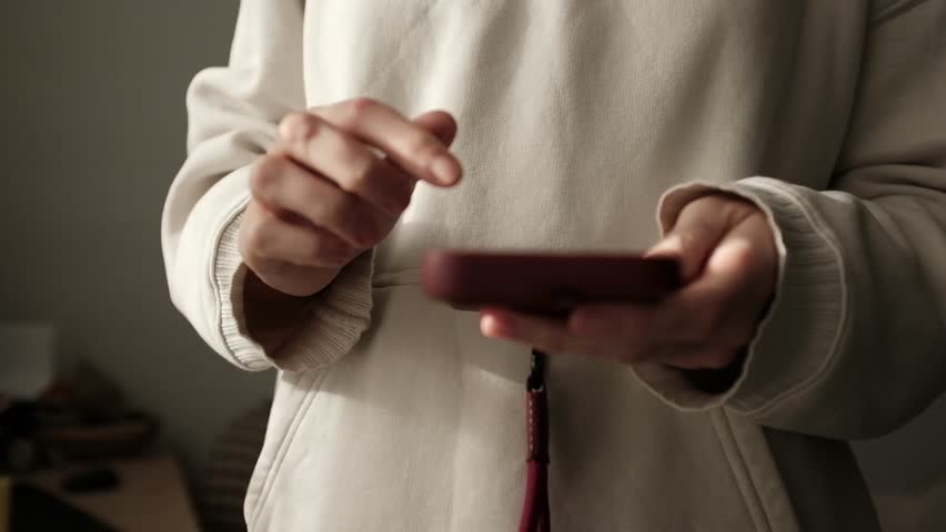 Closeup video of a young woman doom scrolling a smartphone. Addictive behaviour. Modern world problem. Social media marketing. Working through smartphone.