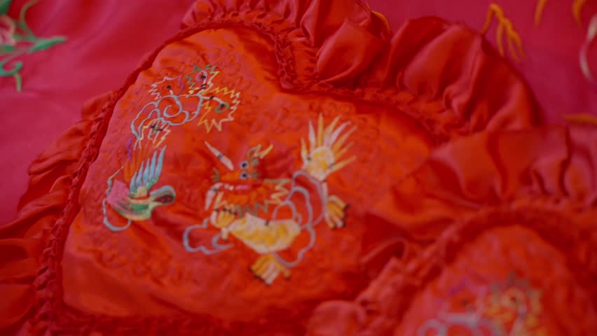 Red silk bedding with embroidered dragon and phoenix symbols.