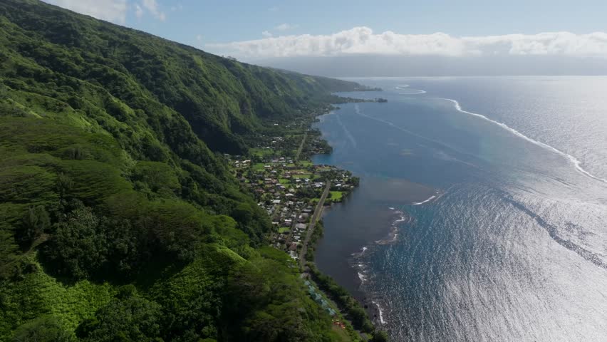 Drone view of the Tahitian coast on a partly cloudy day.