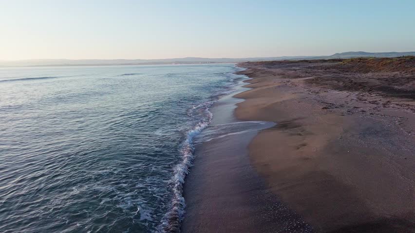 Black Sea and beach nearby against a sky with clouds and a dawn sun