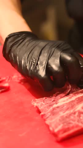 Close up of fresh red beef sliced on vibrant cutting board using large sharp chef knife perfect for culinary photography, food styling, kitchen work, meal preparation and gourmet concept