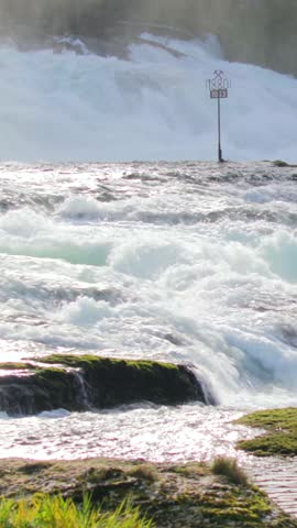 Powerful river rapids flow over rocks in scenic natural landscape