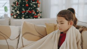A mother shares fruits and cookies with her daughter, who is wrapped in a blanket, in a cozy living room decorated for the Christmas season. - Powered by Shutterstock - Get 15% off with code: PIKWIZARD15