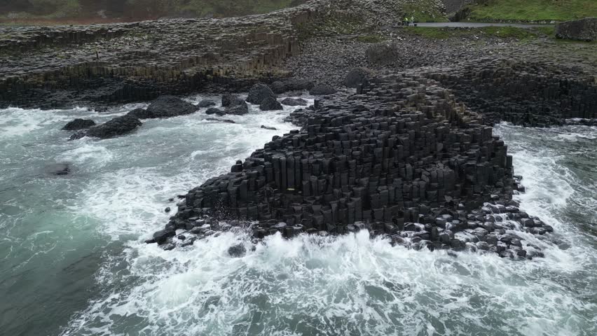A dramatic drone sweep capturing the rugged coastal beauty of Northern Ireland, featuring cliffs, waves, and scenic shoreline landscapes.