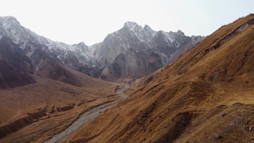 Vast Golden Mountain Landscape with Distant Snow-Capped Peaks