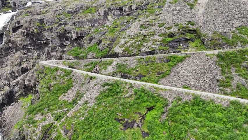 An aerial view of the famous Trollstigen road in Norway, with dramatic switchbacks winding up the steep cliffs of the Isterdalen Valley