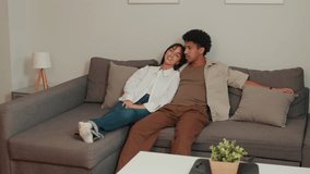 A young couple relaxes on their comfortable sofa, enjoying each other's company in their cozy living room. They find peace and happiness together. - Powered by Shutterstock - Get 15% off with code: PIKWIZARD15