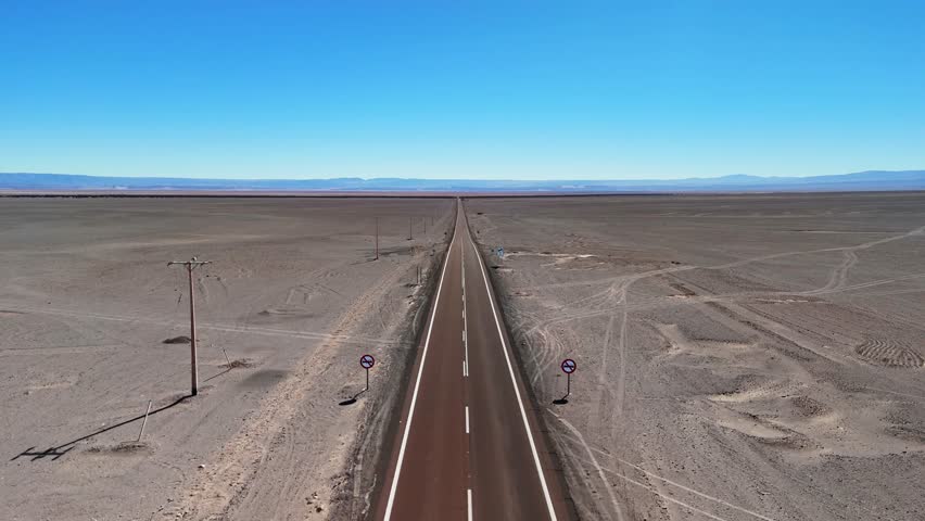 An aerial footage of a car driving on a road cuts through Chile