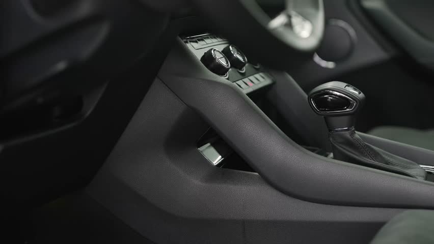 Modern car interior details featuring the dashboard, manual gear shift, and passenger seat with alcantara upholstery and white stitching