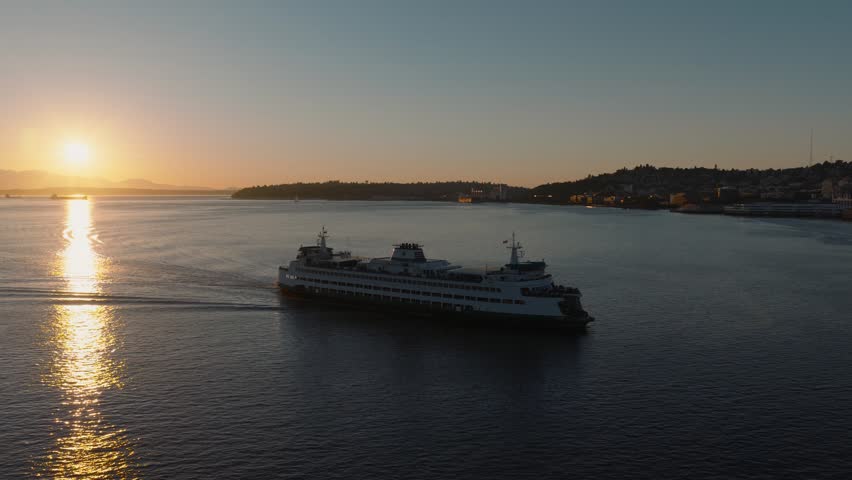 A A ferry sailing across calm waters at sunset near Seattle, with golden reflections on the bay