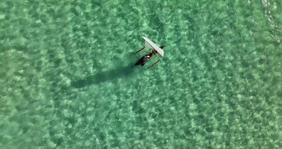 An aerial shot of two Dhow boats sailing in the turquoise water on the coast of Mozambique in Cabo Delgado