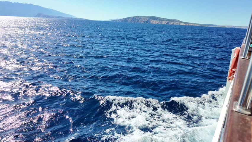 Scenic ocean voyage with vibrant waves and distant mountain views at sea.