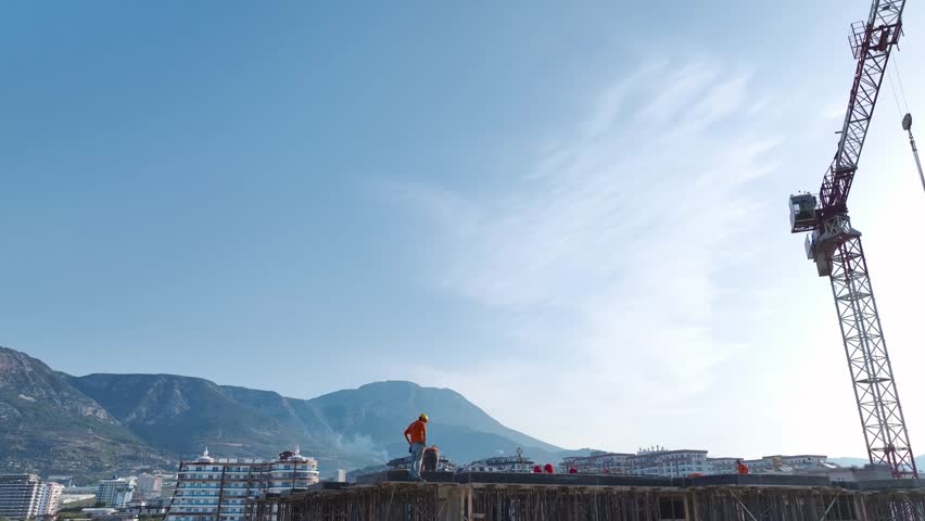 Aerial Video Aerial shot of a construction site with cranes and workers actively building the framework of a new high-rise.