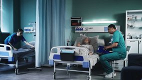Male doctor talking with senior ICU patient while nurse prepares another bed - Powered by Shutterstock - Get 15% off with code: PIKWIZARD15