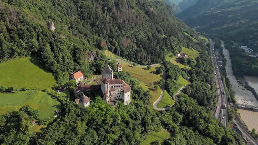 Trostburg Castle on an alpine mountainside, aerial view. Fortified architecture within the Dolomites