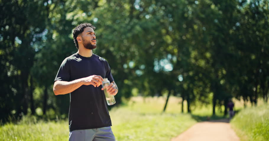 Fitness, man or drink water in nature with break for cooling hydration, check smart watch or wellness. Bokeh, person outdoor or beverage with tech for exercise recovery, electrolytes or step counter.