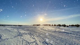 A beautiful sunny winter day with fresh snow, ski tracks and pine trees under a clear blue sky. The sunlight sparkles through falling snowflakes creating a peaceful cold landscape - Powered by Shutterstock - Get 15% off with code: PIKWIZARD15