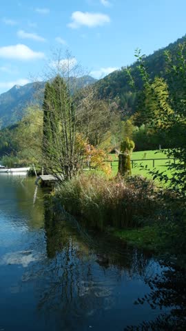 Autumn mountain landscape, mountains near lake, reflections in the water.