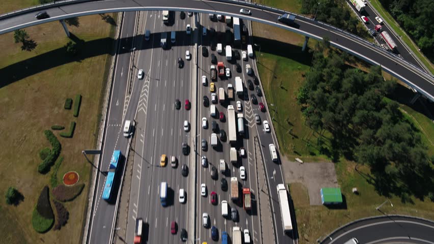 Aerial forward view of busy multilane road and forest corridor