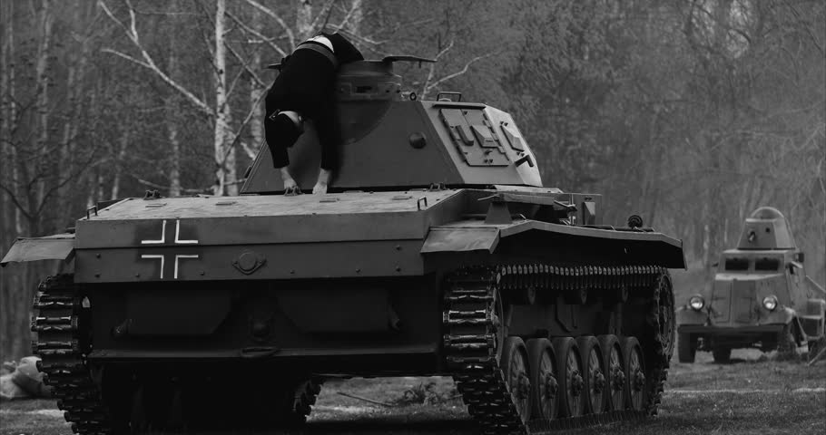 Historical Re-enactment Black And White Video. After Battle. Re-enactor Dressed As Dead German Tank Crew Lies Slain On German Wehrmacht Light Panzer Tank In Reconstruction Of Battles World War Ii.