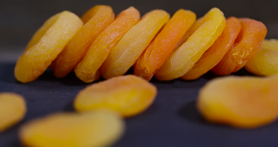 dried ripe apricot fruits on a black slate board, dried seedless pure dried apricots for long-term storage and used as a sweet or for making compotes