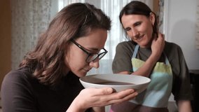 Two women savoring the inviting aroma of freshly prepared hot homemade soup, celebrating warmth, friendship, and the joy of sharing a meal together in a cozy home setting - Powered by Shutterstock - Get 15% off with code: PIKWIZARD15