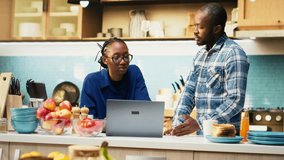 African American furious couple arguing in their kitchen at home. Woman appears angry while man looks upset and distraught, emotional tension and frustration in difficult relationship. Camera B. - Powered by Shutterstock - Get 15% off with code: PIKWIZARD15