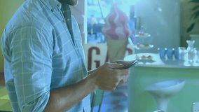 Man tapping smartphone browsing menu at dessert shop, white glyphs drifting over face and growing. Glitch, digital, overlay, cafe, icecream, counter, mobile - Powered by Shutterstock - Get 15% off with code: PIKWIZARD15
