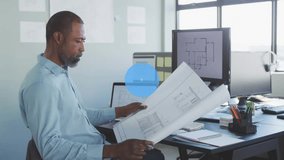 Architect studying plans, monitor showing plan starting blue icons connecting for analyzing plans. Blueprint, architecture, network, interface, office, daylight, focus - Powered by Shutterstock - Get 15% off with code: PIKWIZARD15