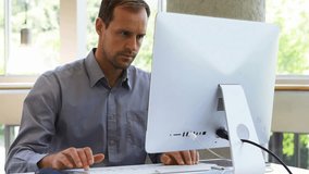 Worker pausing typing, reaching phone and calling while cart icons overlaying screen for business. Office, desk, monitor, multitasking, communication, daylight, modern - Powered by Shutterstock - Get 15% off with code: PIKWIZARD15