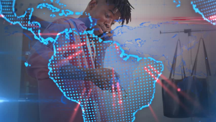 Man answering phone and dispensing liquid at studio, rotating globe overlay revealing business prep. Multitask, workshop, maker, tools, spools, straps, qrcode