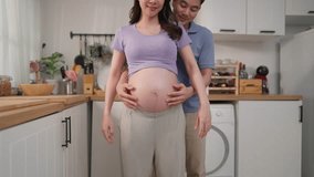 Close up of husband and pregnant wife standing together in kitchen at home. Attractive expectant couple hugging and gently touching her baby bump with love and joy, ready to become parents in future. - Powered by Shutterstock - Get 15% off with code: PIKWIZARD15