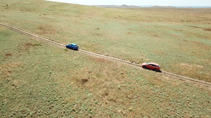 Aerial view. Cars go across the field. General