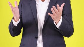 Professional man in suit claps, gestures, and gives thumbs up against bright yellow backdrop - Powered by Shutterstock - Get 15% off with code: PIKWIZARD15
