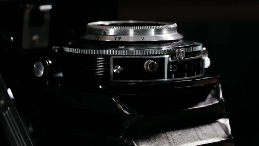 Close view of rotating aperture and shutter ring on vintage folding camera