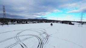 Cinematic FPV drone flyover above a snowy winter field with a single tree, power lines and distant houses. Smooth motion, atmospheric cold tones and wide minimalistic composition. - Powered by Shutterstock - Get 15% off with code: PIKWIZARD15