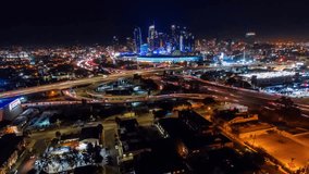 A stunning aerial timelapse of downtown Los Angeles at night, showcasing the Convention Center, illuminated skyline, and fast-moving freeway traffic in a vibrant urban atmosphere. - Powered by Shutterstock - Get 15% off with code: PIKWIZARD15