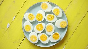 Boiled chicken eggs on a blue plate with yellow wooden background, flat lay top view, symbolizing Easter holidays and festive breakfast concepts. - Powered by Shutterstock - Get 15% off with code: PIKWIZARD15