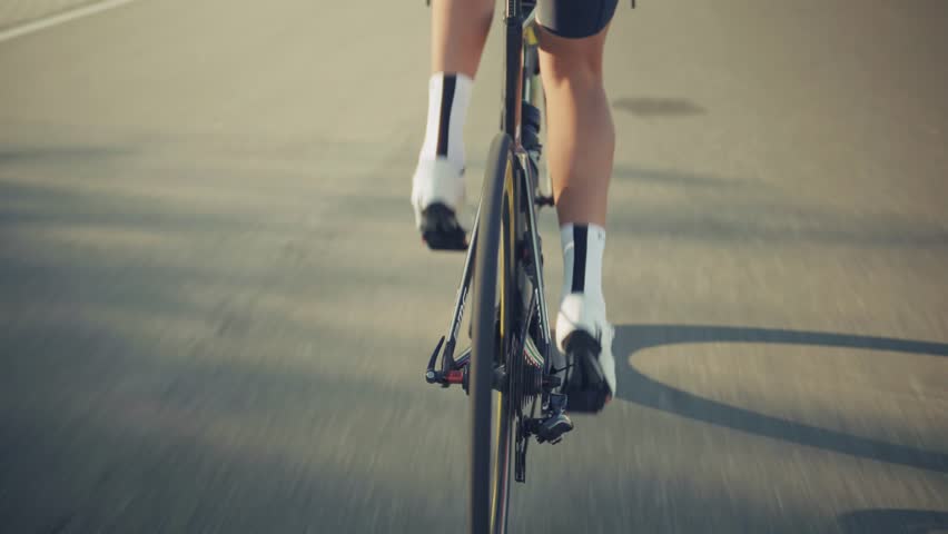 Cyclist Riding Road Bike, Dynamic  Athlete. Professional Cycling Training Outdoors, Endurance Sport And Fitness Challenge, Man In Black Cycling Gear, Race Bike Action. Performance Training Cycling