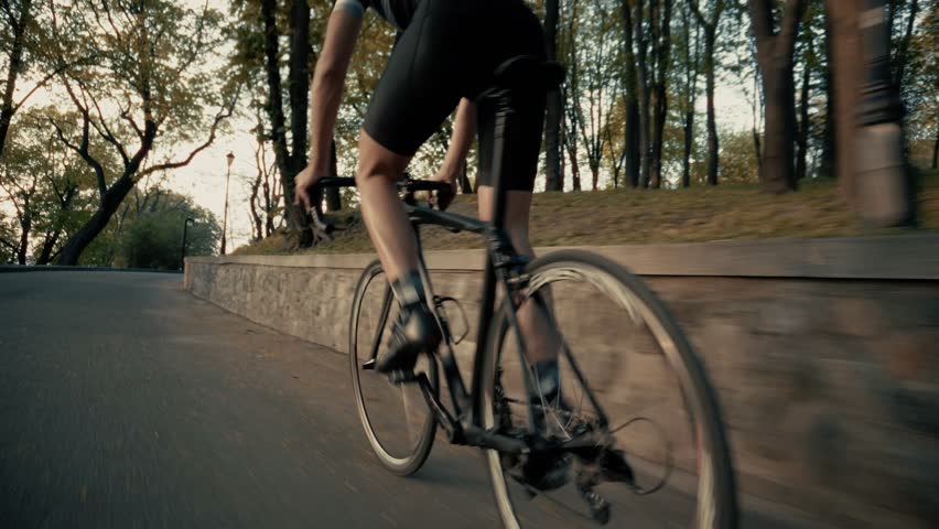 Cyclist Riding Road Bike, Dynamic  Athlete. Professional Cycling Training Outdoors, Endurance Sport And Fitness Challenge, Man In Black Cycling Gear, Race Bike Action. Performance Training Cycling