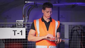 Worker electrician in safety vest opens and types on laptop, focused on operations within an industrial environment. Diligent task completion for maintenance or inventory control. - Powered by Shutterstock - Get 15% off with code: PIKWIZARD15