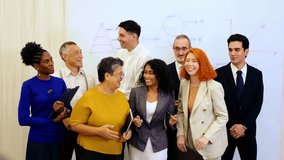 Diverse colleagues celebrate business success in modern office, smiling and cheering by whiteboard. Corporate scene highlights teamwork, leadership, multicultural spirit, and professional unity. 4k - Powered by Shutterstock - Get 15% off with code: PIKWIZARD15