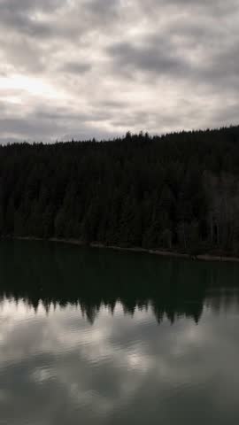 Calm Lake and Forest Reflecting Cloudy Skies in British Columbia, Canada