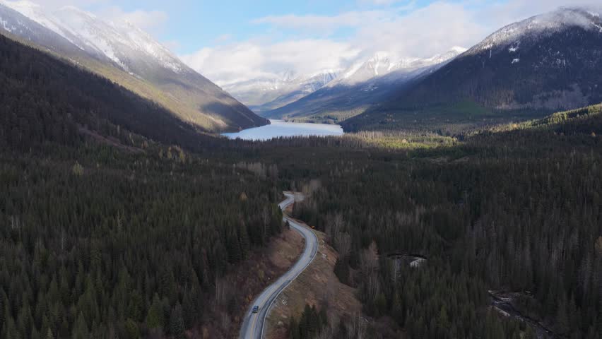 Winding Road Through Majestic Forest Valley to a Serene Lake in British Columbia, Canada