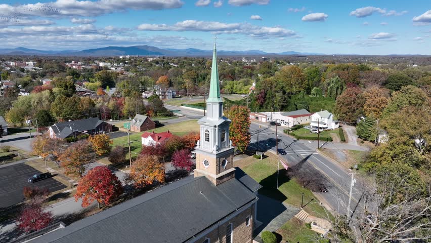 Aerial approacjing shot f church tower with driving cars on Main Street. Sunny day in small sitoric town of uSA. Lynchburg,Virginia in Autumn season. Wide shot.