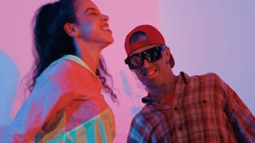 Close up of break dancer team dancing together at modern studio with pink led light. Multicultural people moving to hip hop music while wearing stylish fashion cloth. Crazy, funny mood. Regalement. - Powered by Shutterstock - Get 15% off with code: PIKWIZARD15