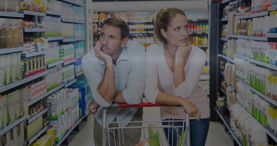 Couple leaning on cart, scanning grocery shelves, initiating digital overlays obscuring view. Duo, shoppers, aisle, retail, candid, reflections, glitch