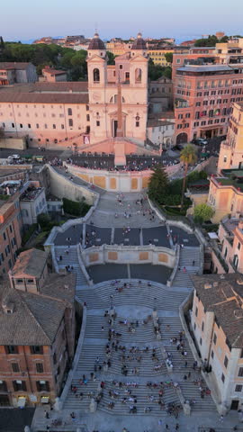 Breathtaking aerial footage highlights Rome iconic Spanish Steps at sunset, showcasing the vibrant city life and remarkable architecture surrounding this historic landmark. Italy